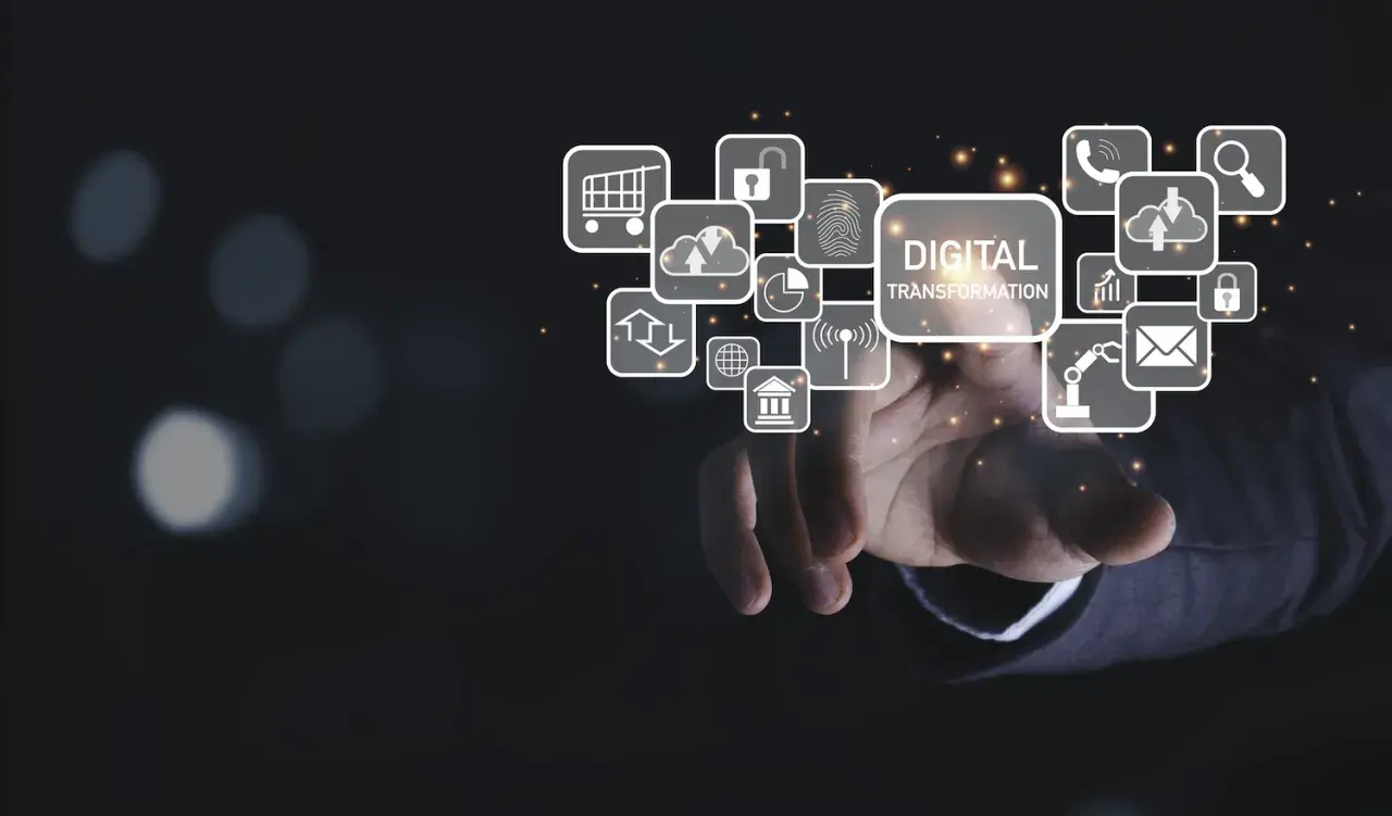 Mano interactuando con iconos de transformación digital: carrito de compras, candado, huella dactilar, nube, gráfico, teléfono, lupa, email, robot, banco.